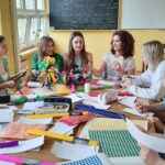 Uczenicy przy stole z materiałami plastycznymi