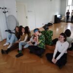 uczniowie siedzący na podłodze