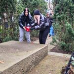 uczennice ze zniczem przy grobie