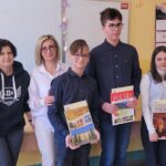 uczniowie i nauczyciele z dyplomami i nagrodami