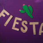 kaktus i napis "fiesta wycięte z kartonu na fioletowym tle