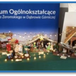 tło II LO w Dąbrowie Górniczej, na pierwszym planie szopka bożonarodzeniowa