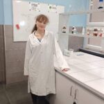 uczennica w fartuchu na tle laboratorium chemicznego