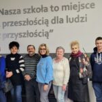 dyrektor szkoły wraz z bibliotekarzem pozujący do zdjęcia z gośćmi z klubu "Jutrzenka"