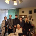 uczniowie wraz z dyrektorem szkoły pozujący do zdjęcia ze świadkiem historii