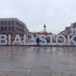 uczeń pozujący przy napisie "Białystok"