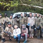 uczniowie w strojach do paintballa z nauczycielami