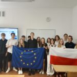 uczniowie trzymający flagi Polski i UE