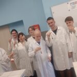 uczniowie w odzieży ochronnej w laboratorium