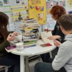 uczniowie z książkami w bibliotece szkolnej