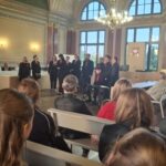 ludzie siedzący na sali sądowej