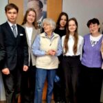 uczniowie stojący starszą panią