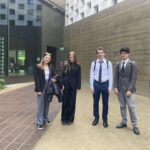 uczniowie stojący przed budynkiem