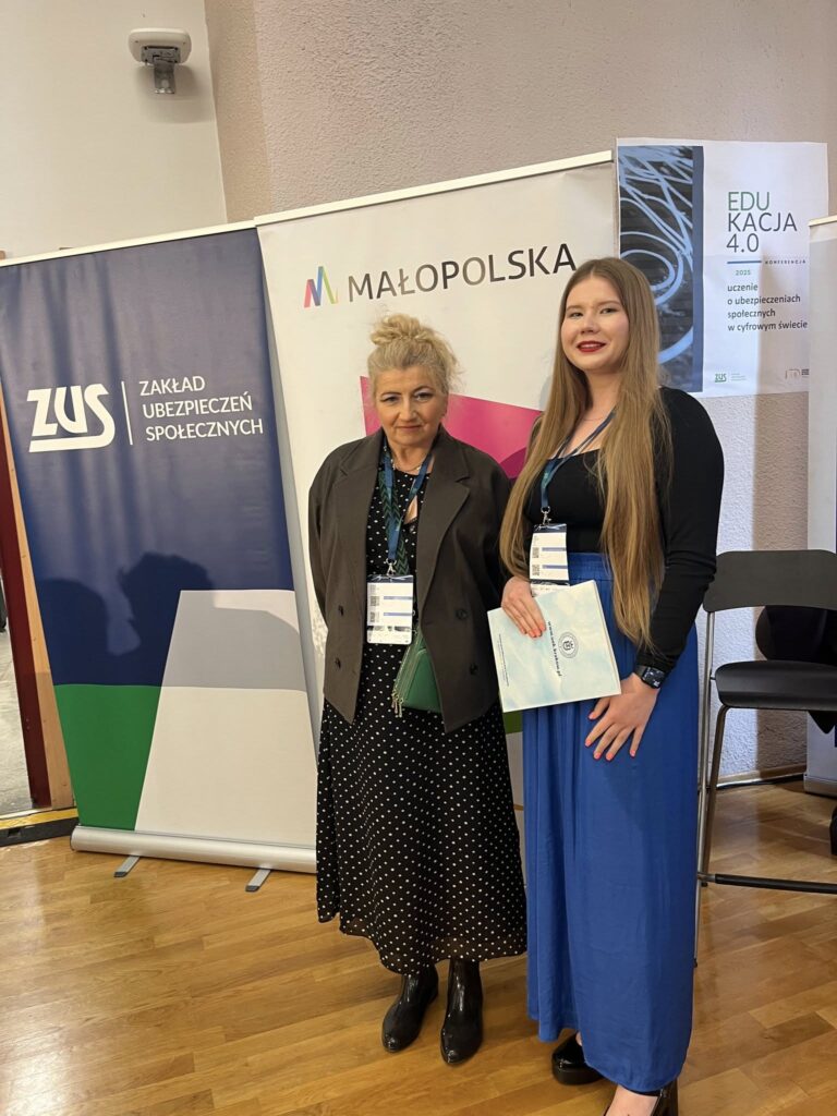 nauczyciele stojący na tle baneru wydarzenia