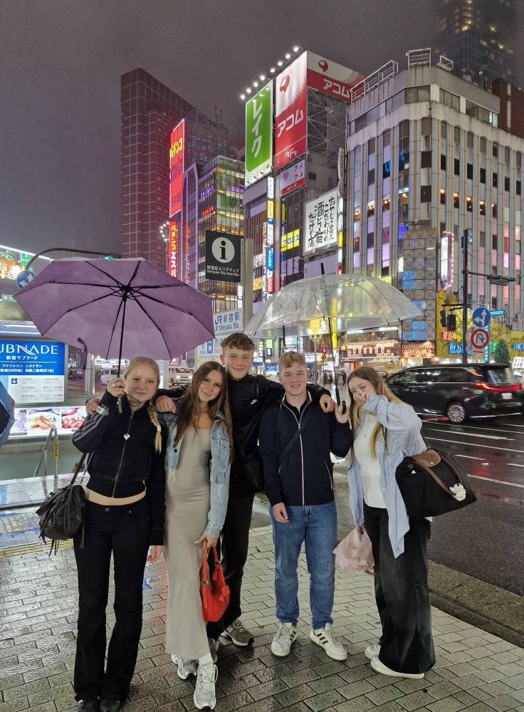 uczniowie pod parasolami