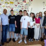 uczniowie pozujący do zdjęcia z gościem