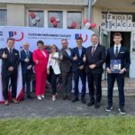 dyrekcja, z zaproszonymi gośćmi i przewodniczącym szkoły pozujący do zdjęcia