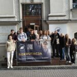 uczniowie z nauczycielem przed gmachem uczelni