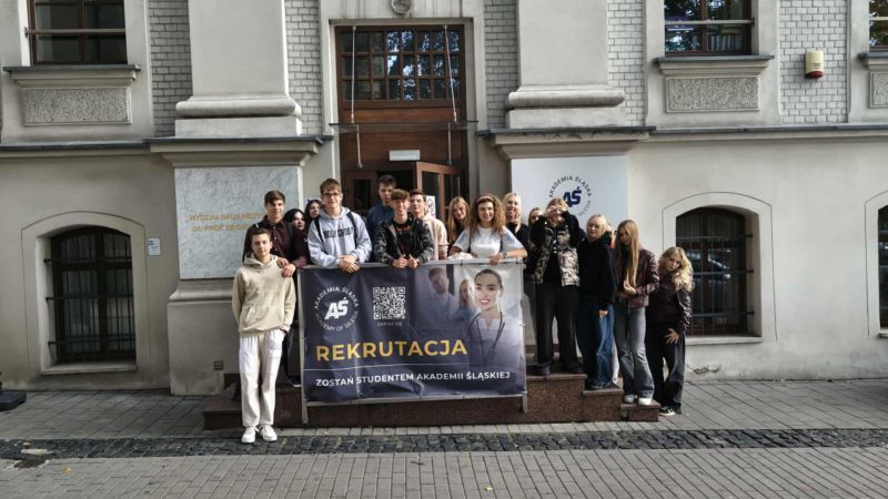 uczniowie z nauczycielem przed gmachem uczelni